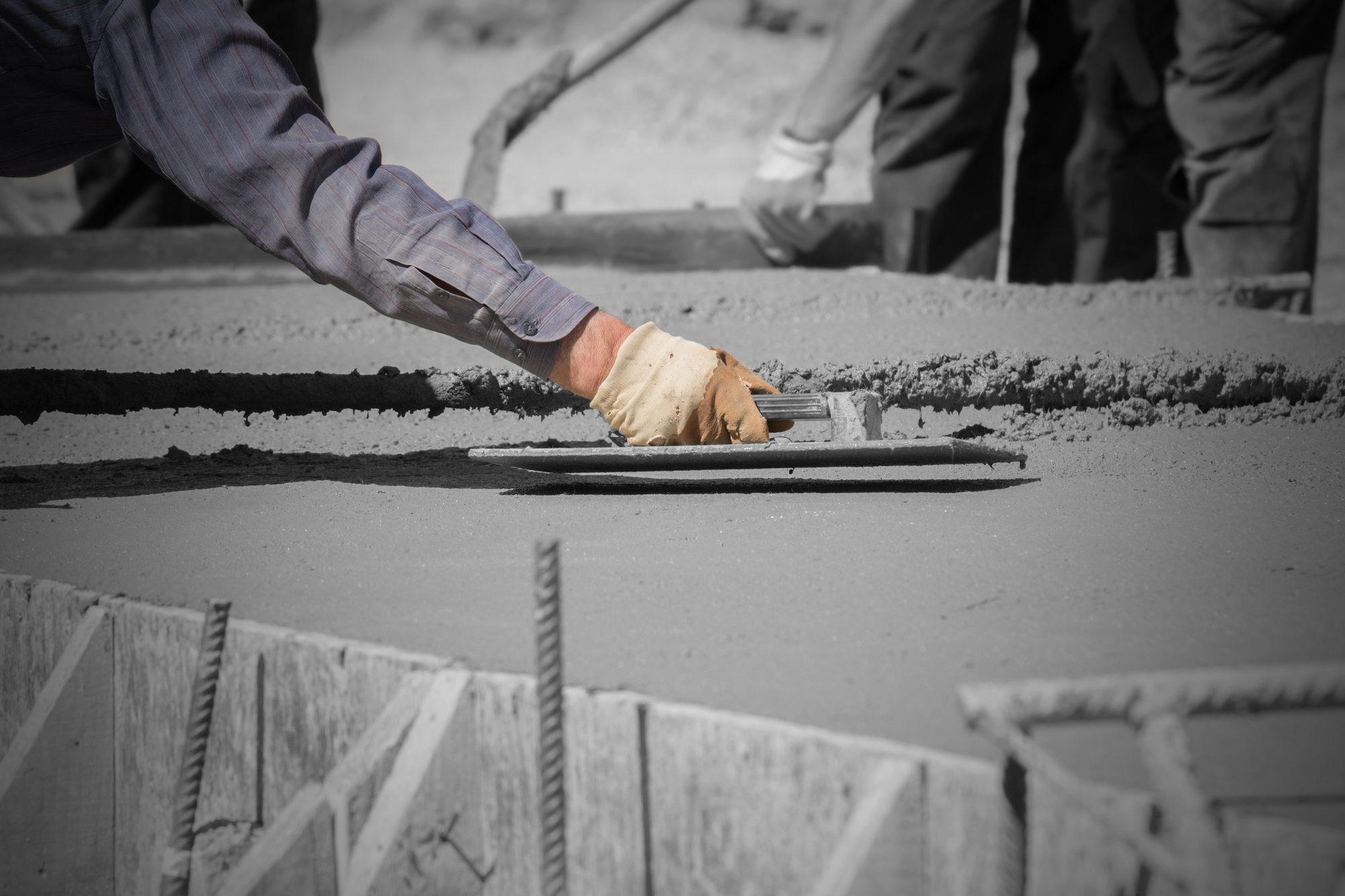 Construction workers leveling concrete pavement